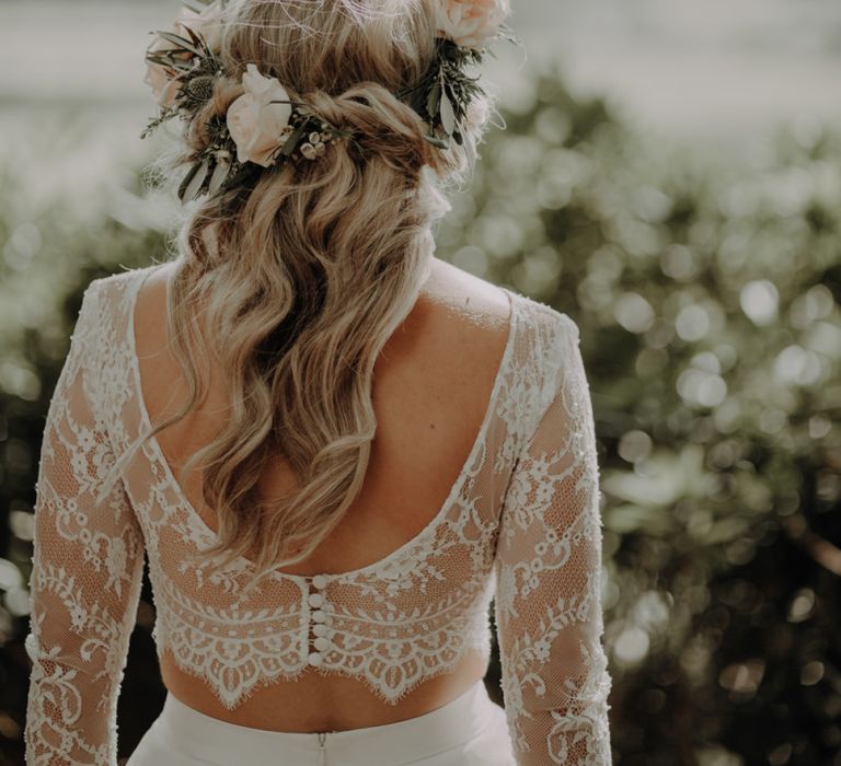 Back of brides lace two piece dress wearing white rose floral head piece