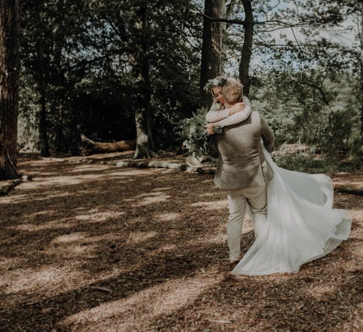 Bride and groom embrace at outdoor country wedding with festival touches