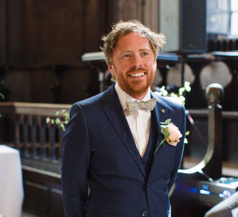 Groom in Navy Blue Ted Baker Suit with Floral Bow Tie