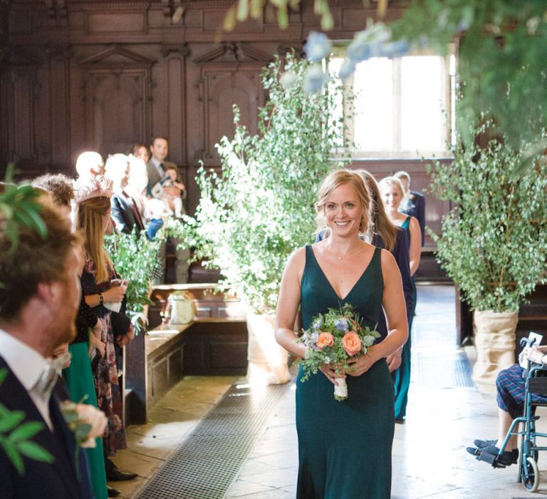 Bridesmaid Walking Down the Aisle in Forest Green Jenny Yoo Dress