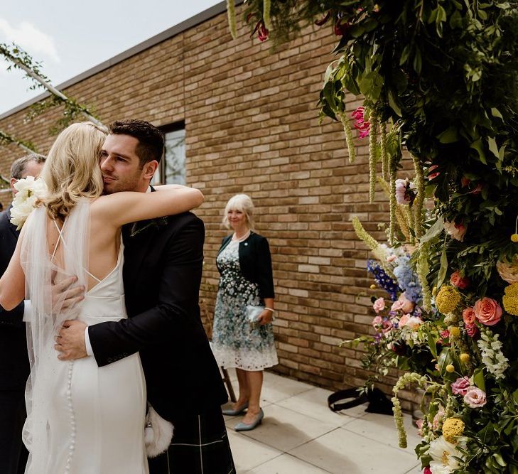 Bride and groom tie the knot at a private rooftop wedding in London with floral decor