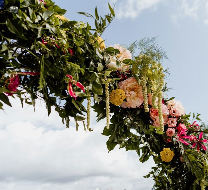 Bright multi-coloured florals for an outdoor whimsical celebration with a bridal jumpsuit