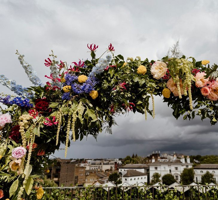 Beautiful multi-colour floral moon gate at rooftop wedding in London