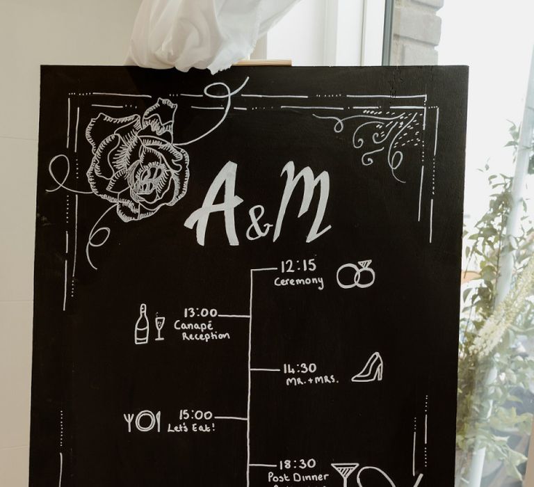 Chalkboard wedding sign at private rooftop wedding with bridal jumpsuit