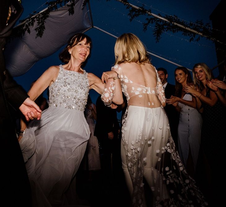 Bride wearing bridal jumpsuit at outdoor disco reception