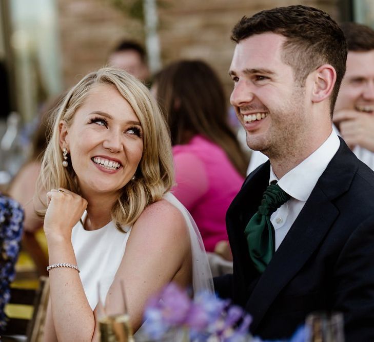 Bride and groom at outdoor wedding with bridal jumpsuit