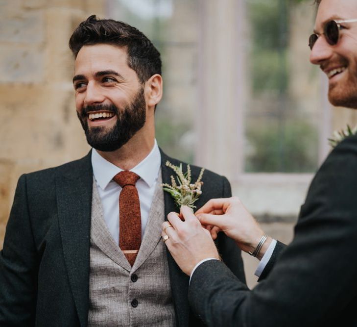 Groom wearing three piece suit and floral buttonhole at Newburgh Priory