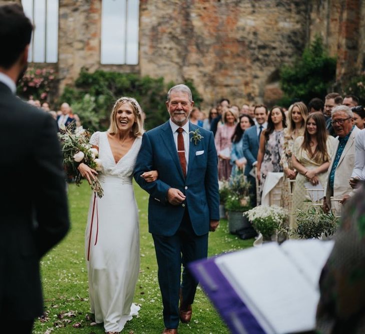 Bride walking down the aisle at outdoor wedding ceremony