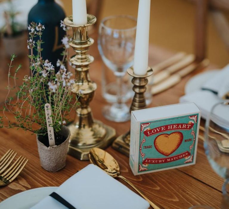 Gold candlesticks with white taper candles at marquee reception