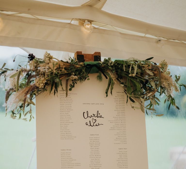 Table plan with white foliage decor at marquee reception