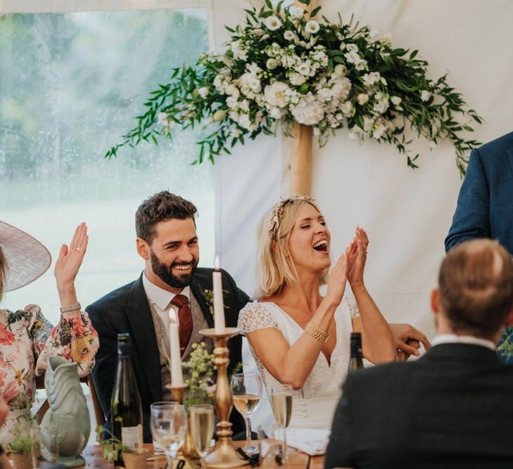 Bride and groom celebrate at their reception with white floral decor