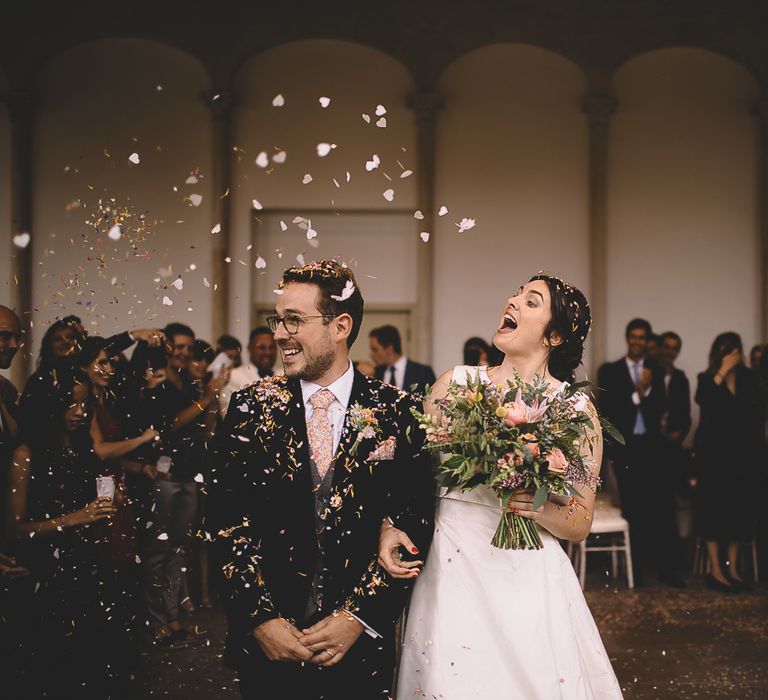 Bride and Groom Having Confetti Thrown Over Them