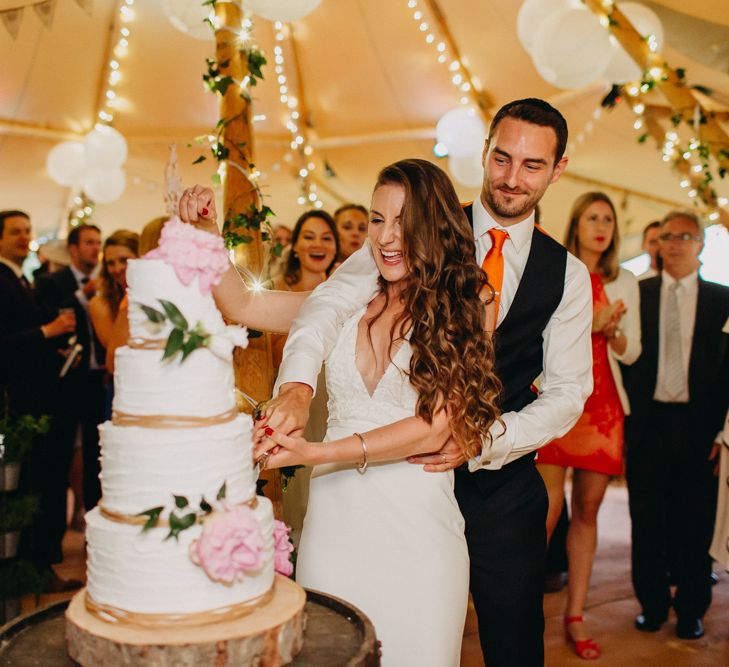 Cutting the Wedding Cake | Bride in Halo &amp; Wren Wedding Dress | Groom in Moss Bros. Suit | DIY Rustic Tipi Wedding at Riverhill Gardens, Sevenoaks | Frances Sales Photography