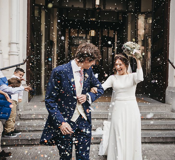 Confetti Moment with Bride in Nnavascues Embroidered Back Wedding Dress and Groom in Navy Suit