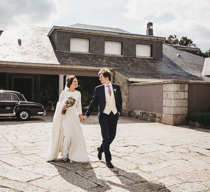 Bride in Nnavascues Embroidered Back Wedding Dress and Groom in Navy Suit