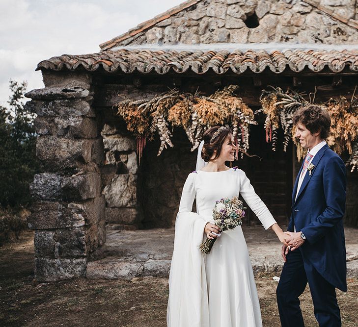 Bride in Nnavascues Embroidered Back Wedding Dress and Groom in Navy Suit