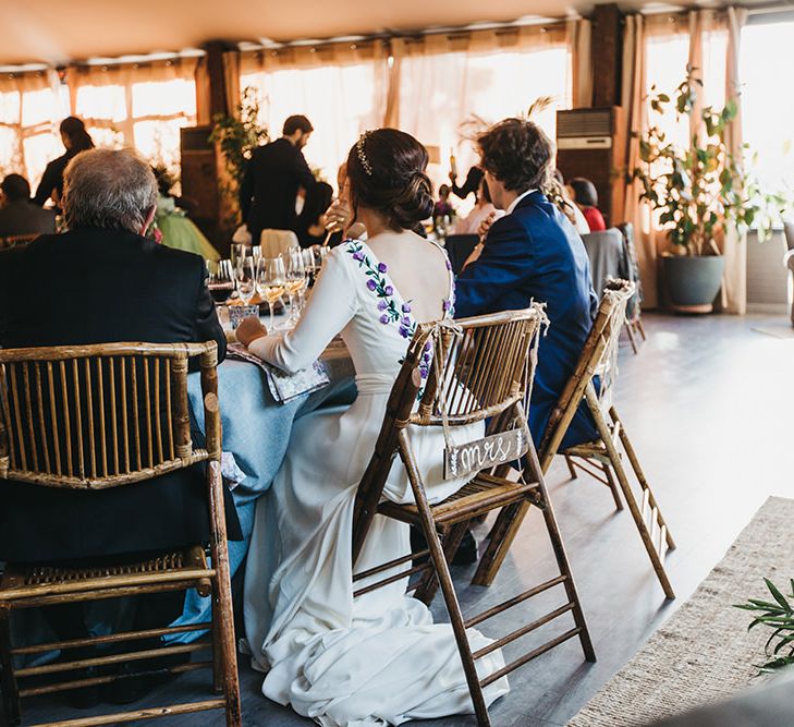 Bride in Nnavascues Embroidered Back Wedding Dress and Groom in Navy Suit Entering The Wedding Reception