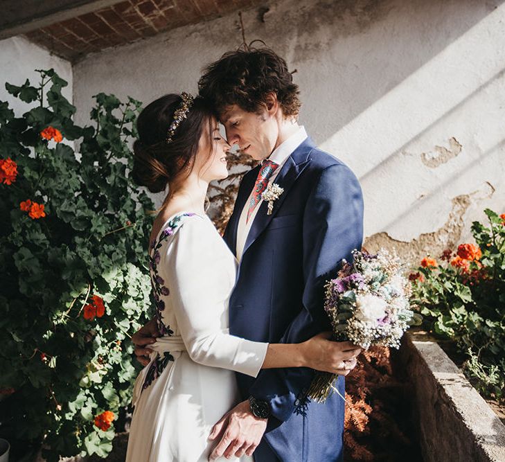 Bride in Nnavascues Embroidered Back Wedding Dress and Groom in Navy Suit