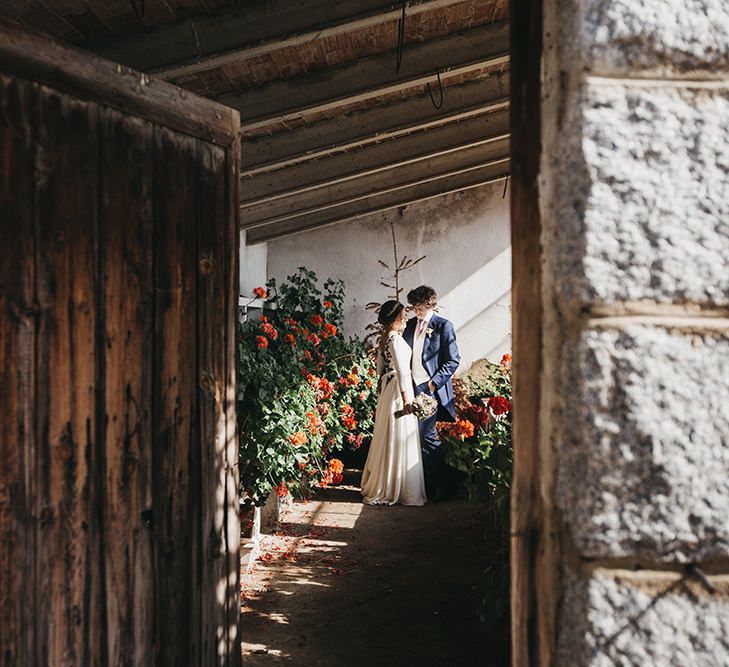 Bride in Nnavascues Embroidered Back Wedding Dress and Groom in Navy Suit