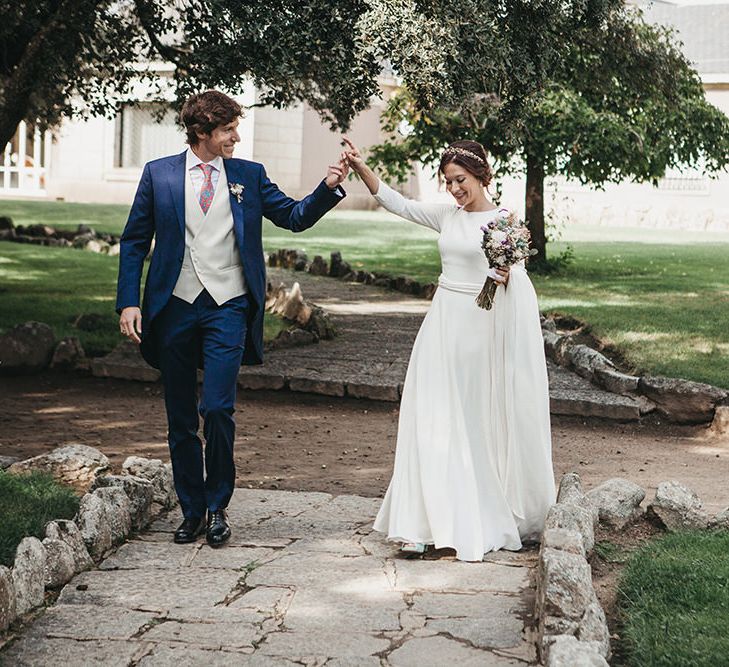 Bride in Nnavascues Embroidered Back Wedding Dress and Groom in Navy Suit