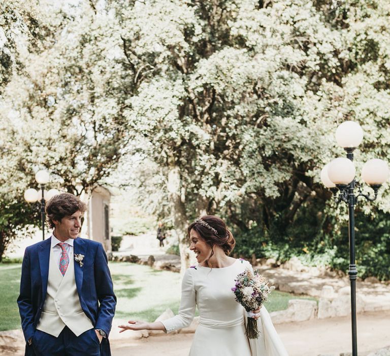 Bride in Nnavascues Embroidered Back Wedding Dress and Groom in Navy Suit