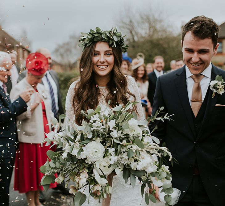 Confetti Moment with Boho Bride in Lace Wedding Dress and Flower Crown  with Groom in Moss Bros. Suit