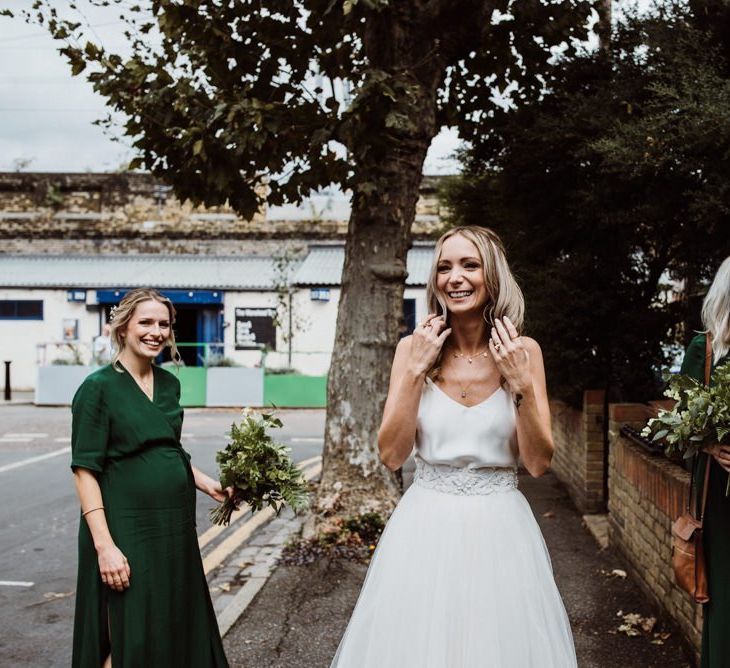 Bride wearing two piece Halfpenny London dress and her bridesmaids wearing emerald green dresses at Stoke Newington Town Hall