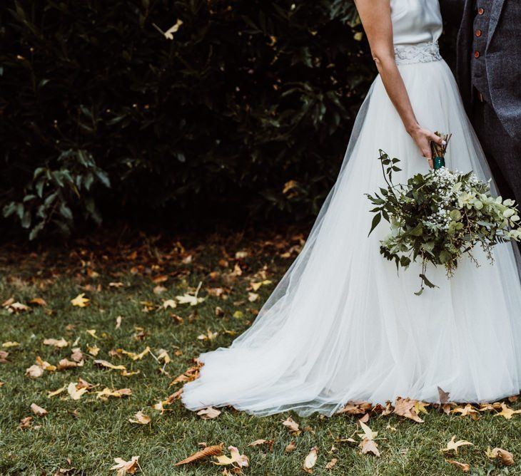 Brides wearing Halfpenny London dress with beautiful foliage bouquet