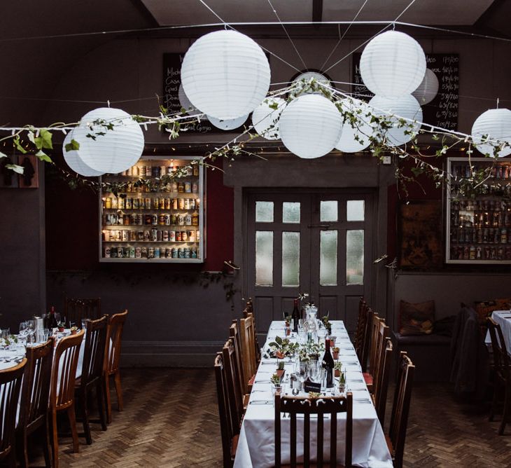 Reception styling with hanging foliage and white paper lantern decor