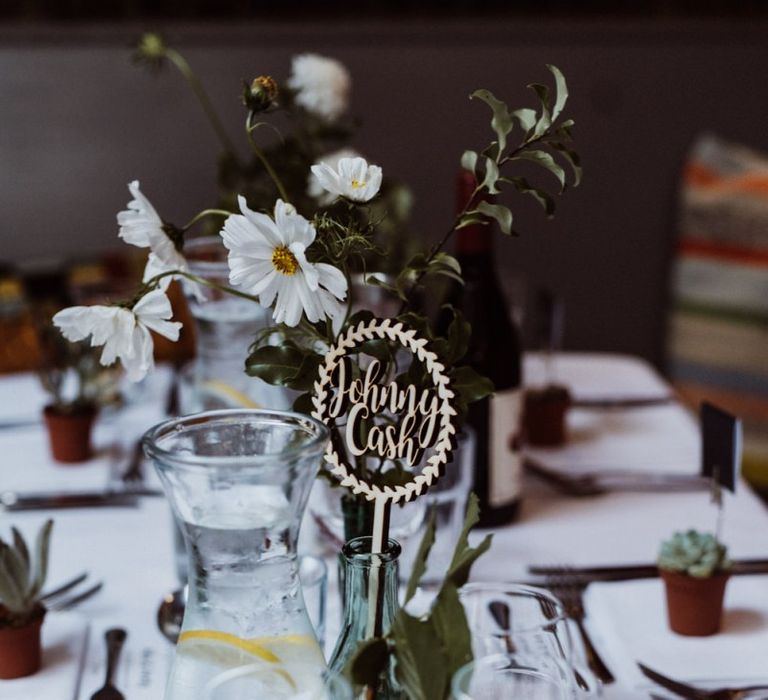 Laser cut signs and glass vases with floral arrangements