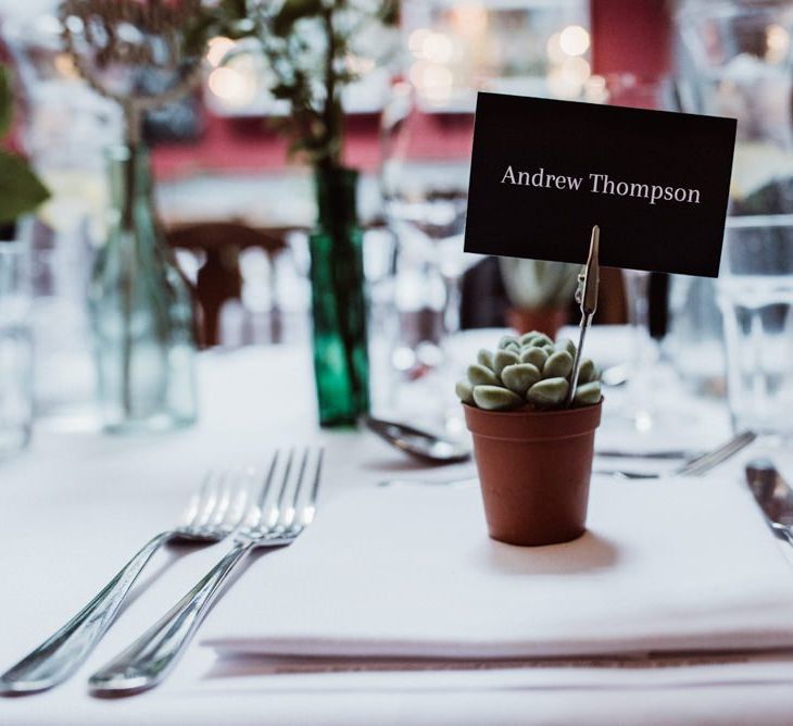 Succulent plant place settings at pub reception with foliage decor