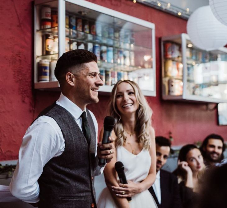 Bride and groom enjoy the toasts at relaxed party pub reception