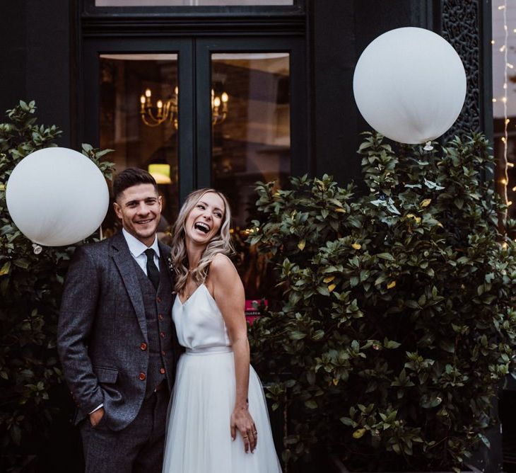 Bride and groom at pub reception with white paper lantern decor