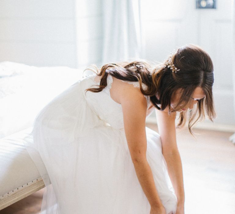 Bride on her wedding morning putting on her pink bridal shoes