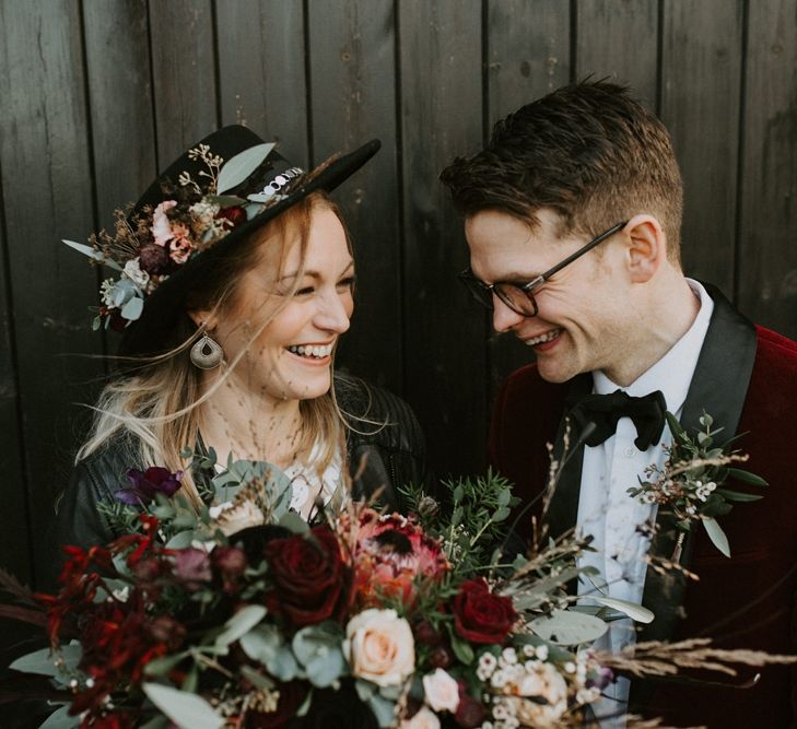 Bride in Floral Fedora Hat and Leather Jacket with Groom in Red Velvet Jacket