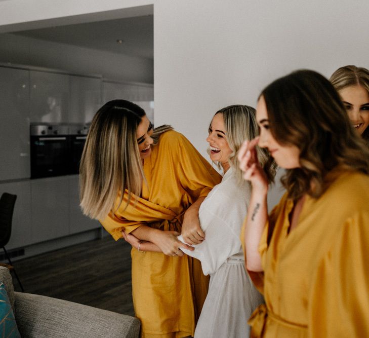 Bridesmaids in matching ochre getting ready robes