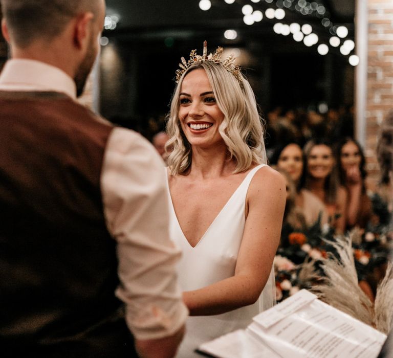 Wedding ceremony with bride in gold bridal crown with jewels by Howling Moon