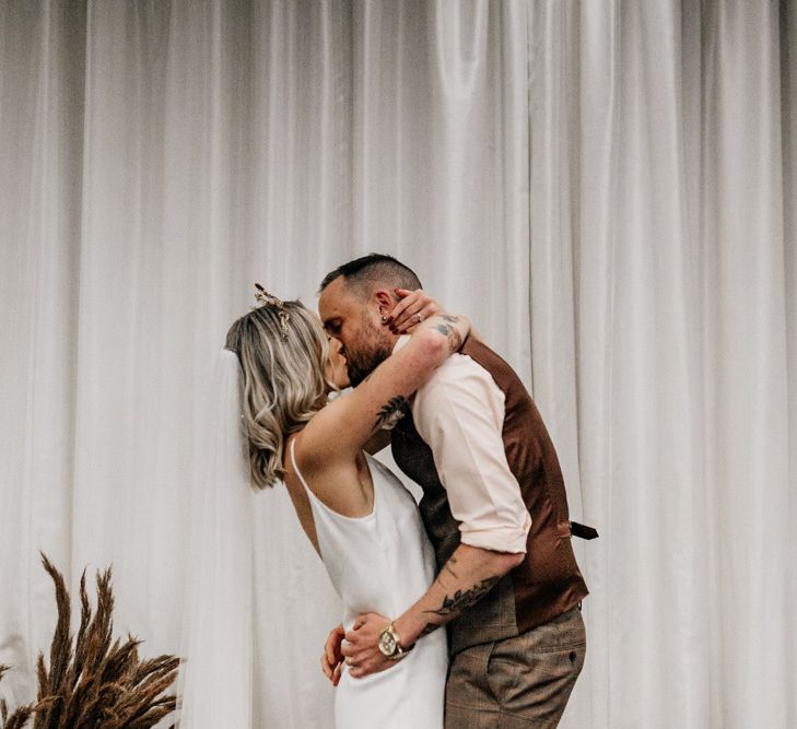 Bride and groom embracing during wedding ceremony at New Craven Hall