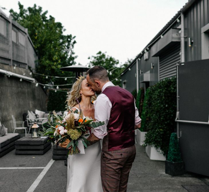 Bride and groom kissing in the courtyard at New Craven Hall , Leeds