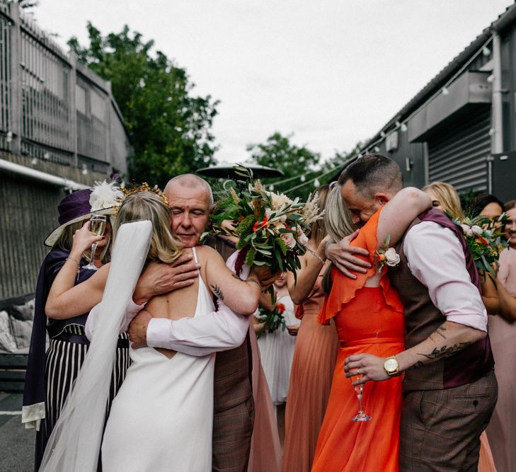 Wedding guests hugging the bride and groom