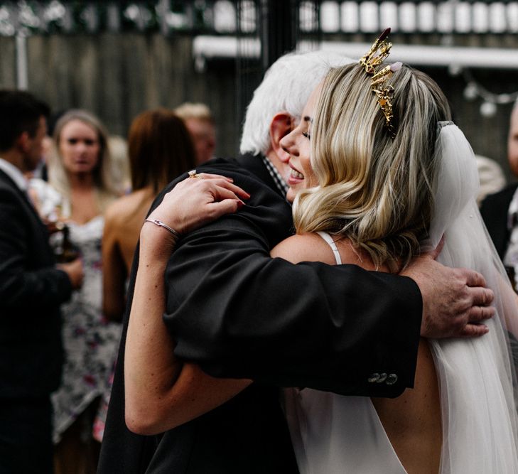 Wedding guest hugging the bride in gold crown