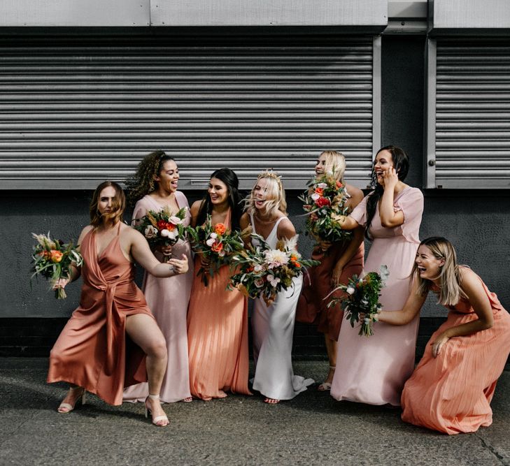 Fun bridal party portrait with bridesmaids in coral dresses