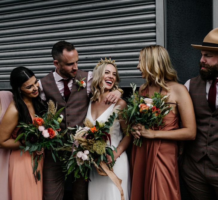 Bride in gold crown laughing with her bridesmaid