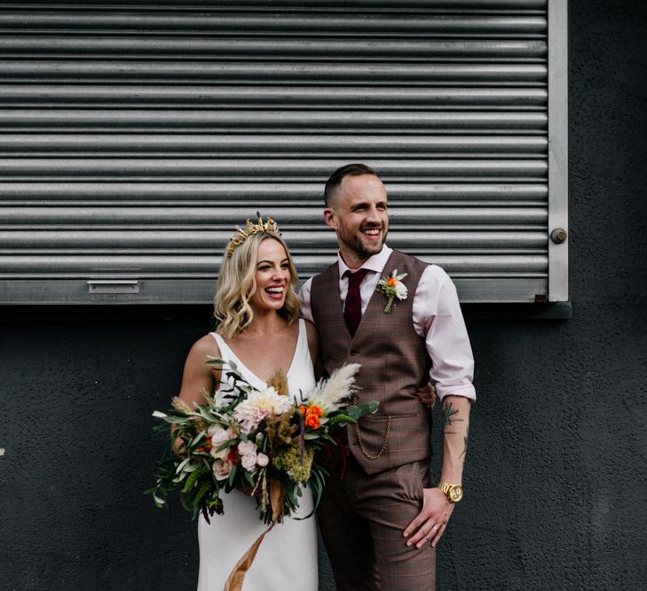 Stylish bride and groom portrait in front of metal shutters