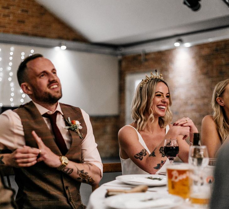 Bride and groom laughing during wedding reception speeches