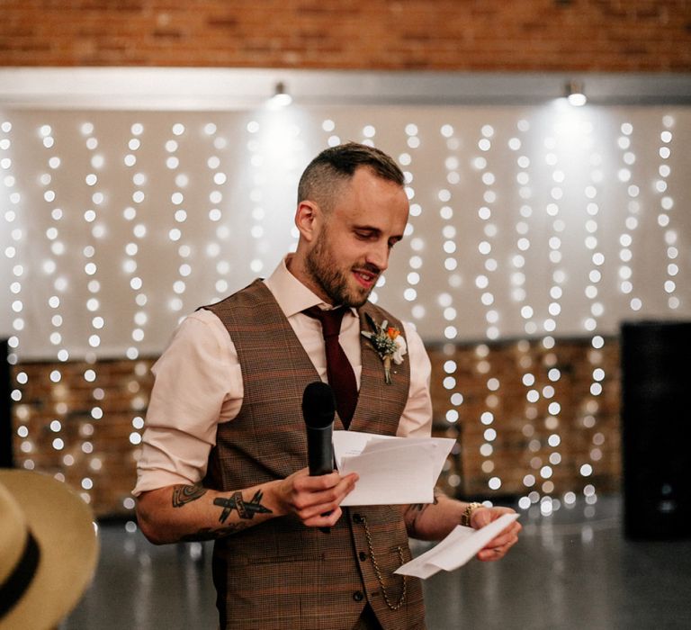 Groom in brown check waistcoat delivering his wedding speech