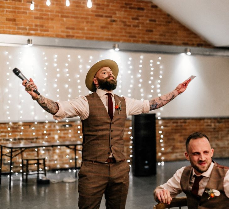 Best man in brown check waistcoat and hat delivering his wedding speech