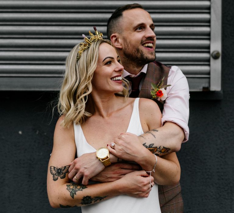 Stylish bride and groom embracing with bride in gold bridal crown