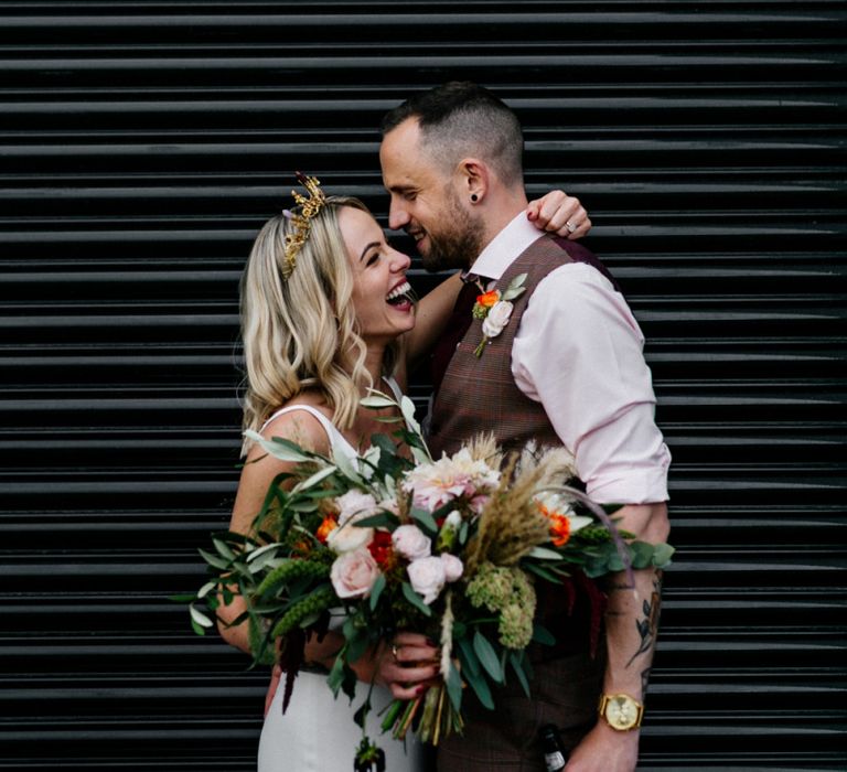 Bride in gold crown holding an oversized bouquet