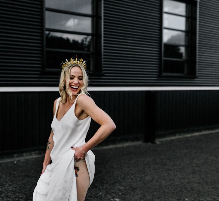 Beautiful bride in slip wedding dress and gold bridal crown showing her tattoos